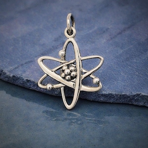 May include: A silver atom charm pendant with a detailed design of a nucleus and orbiting electrons.