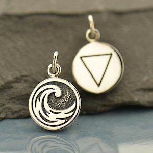 May include: Two silver charms, one with a wave design and the other with a triangle inside a circle. Both charms are on a gray background.