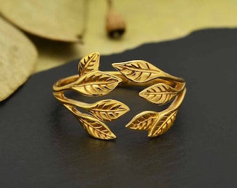 May include: Gold leaf ring with a delicate design. The ring features five leaves arranged in a symmetrical pattern, creating a natural and elegant look.