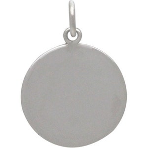 May include: A silver round charm with a smooth surface and a loop at the top for attaching to a necklace or bracelet.