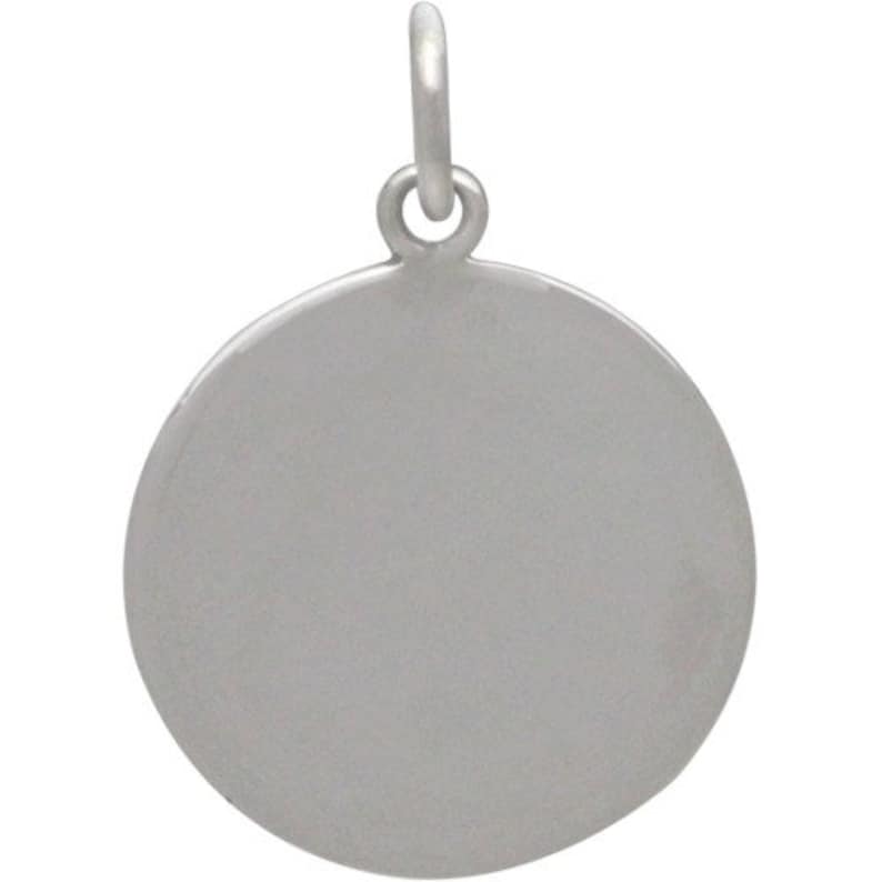 May include: A silver round charm with a smooth surface and a loop at the top for attaching to a necklace or bracelet.