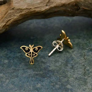 May include: A pair of gold-tone earrings featuring a black and gold butterfly design. The earrings have a post and butterfly back closure.