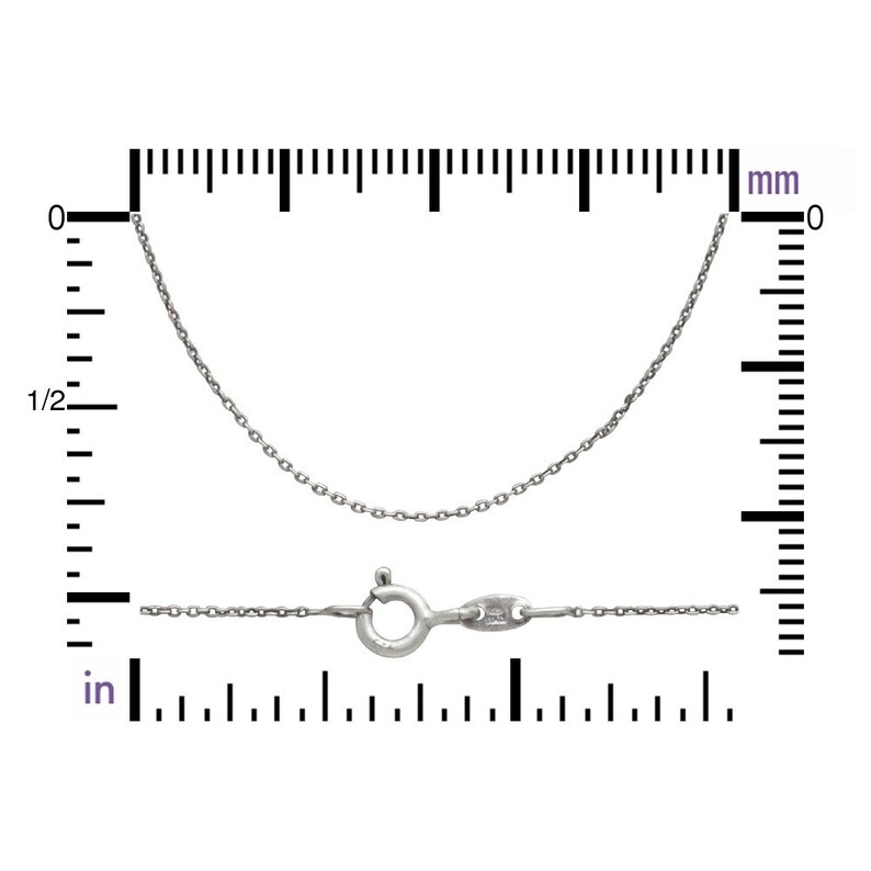 May include: A silver chain necklace with a lobster clasp. The chain is 18 inches long and is shown against a ruler.