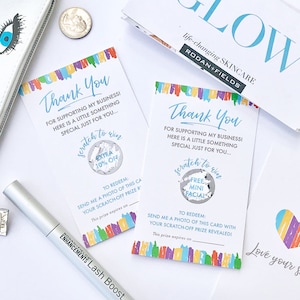 May include: Two colorful thank you cards with scratch-off circles. The cards have a rainbow stripe design and the text "Thank You for supporting my business! Here is a little something special just for you..." One card has a scratch-off circle that says "Extra 10% Off" and the other says "Free Mini Facial".