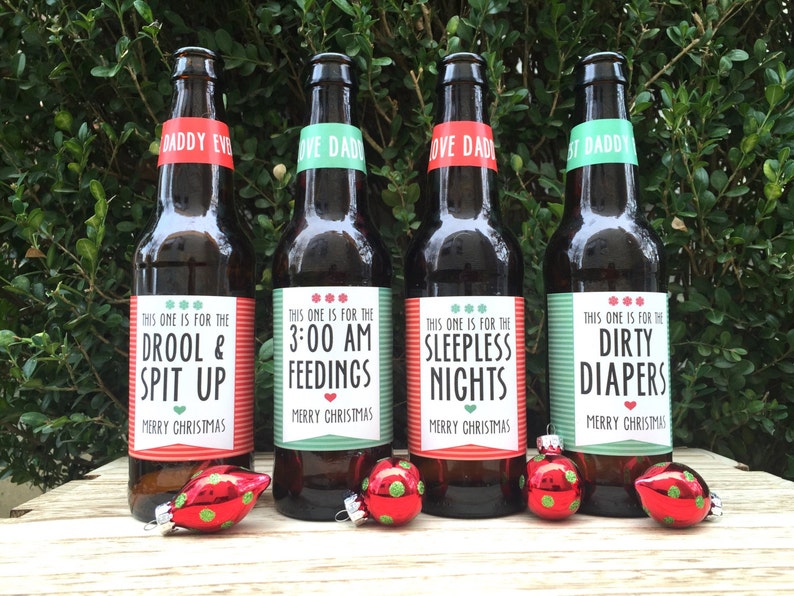May include: Four brown beer bottles with green and red labels. The labels have text that reads "This one is for the Drool & Spit Up", "This one is for the 3:00 AM Feedings", "This one is for the Sleepless Nights", and "This one is for the Dirty Diapers". Each label has the text "Merry Christmas" at the bottom.