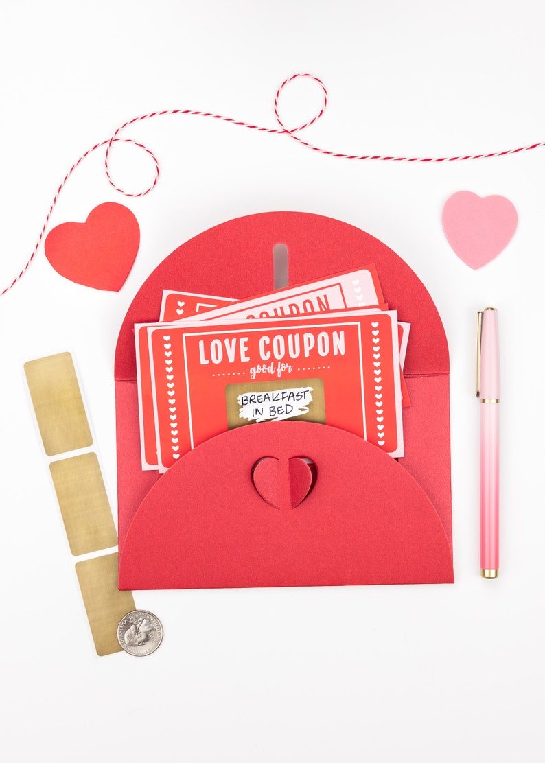 Puede incluir: Sobre rojo con una abertura en forma de coraz&oacute;n, que contiene una pila de cupones de amor rosa y rojo con el texto "LOVE COUPON good for BREAKFAST IN BED".