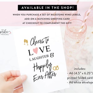 Pode incluir: Um cart&atilde;o de felicita&ccedil;&otilde;es branco com texto preto que diz "Cheers to LOVE LAUGHTER & Happily Ever After". O cart&atilde;o apresenta um cora&ccedil;&atilde;o rosa e ta&ccedil;as de champanhe douradas. O cart&atilde;o mede 11,4 cm x 15,9 cm e inclui um envelope branco.