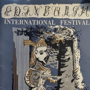 May include: A blue and gold souvenir programme for the Edinburgh International Festival in 1955. The cover features a whimsical illustration of a jester playing a violin in front of a doorway.