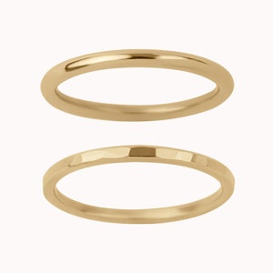 May include: Two gold rings, one with a smooth finish and the other with a hammered texture.