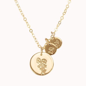 May include: A gold necklace with three charms. The largest charm features a floral design, while the two smaller charms are plain.
