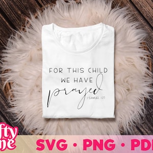 May include: White t-shirt with black text that reads "For this child we have prayed I Samuel 1:21".