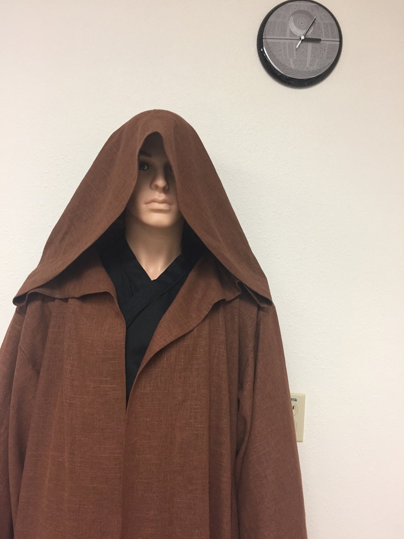 May include: A brown hooded robe with a long, flowing design. The robe is made of a soft, textured fabric.