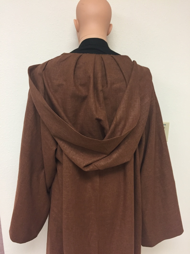 May include: A brown hooded robe with a long, flowing design. The robe is made of a soft, textured fabric.