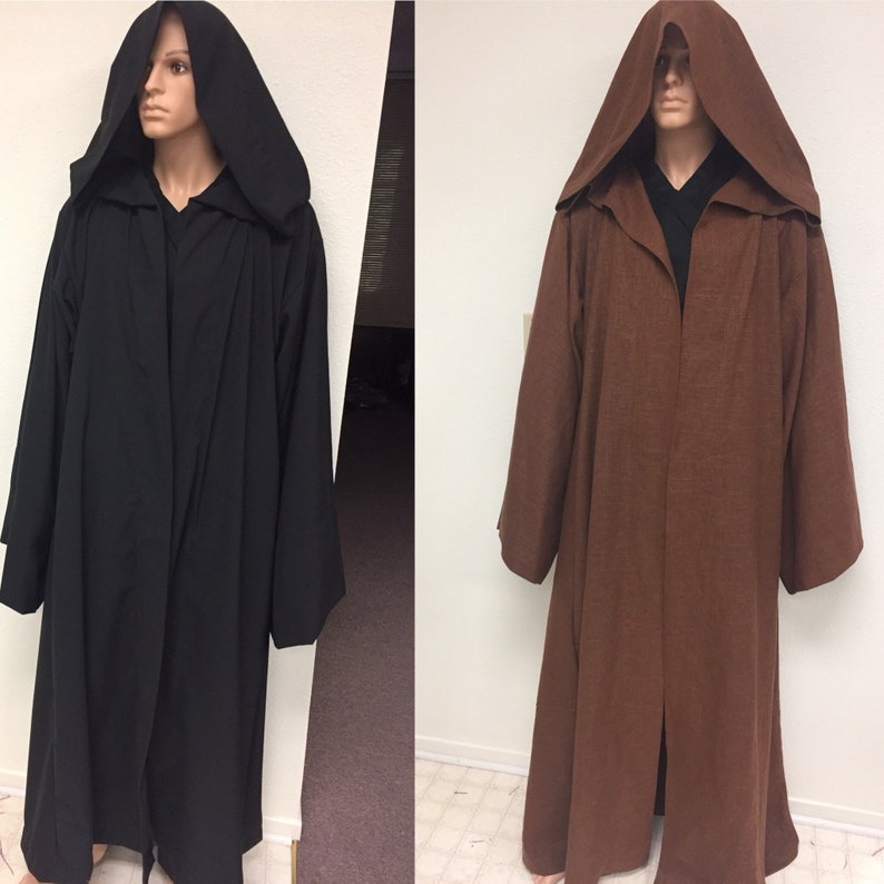May include: Two hooded robes, one black and one brown, are shown hanging on mannequins. The robes have long sleeves and a long, flowing design.