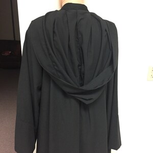 May include: Black hooded robe with a pleated back and long sleeves.