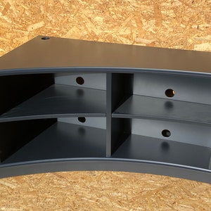 Puede incluir: Soporte de TV de esquina curvo negro con tres estantes y m&uacute;ltiples orificios para la gesti&oacute;n de cables.