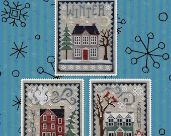 May include: Three cross-stitch patterns for a winter-themed sampler. The first pattern features a house with a snowy roof and the word "Winter" above it. The second pattern features a red house with a snowy roof and the word "January" below it. The third pattern features a green house with a snowy roof and the word "February" below it.