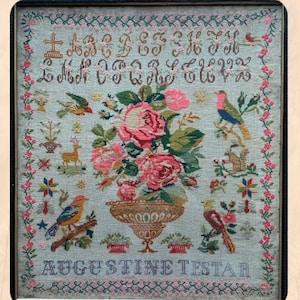 May include: A rectangular needlepoint sampler on light blue fabric featuring a central urn filled with pink roses, surrounded by embroidered birds, a deer, a squirrel, floral borders, the alphabet in brown script, and the text AUGUSTINE TESTAR.