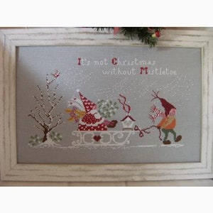 May include: Cross-stitch pattern featuring two gnomes, one in a red and white outfit pulling a sleigh with a birdhouse, and the other in a yellow and orange outfit. The text "It's not Christmas without Mistletoe" is above the gnomes.