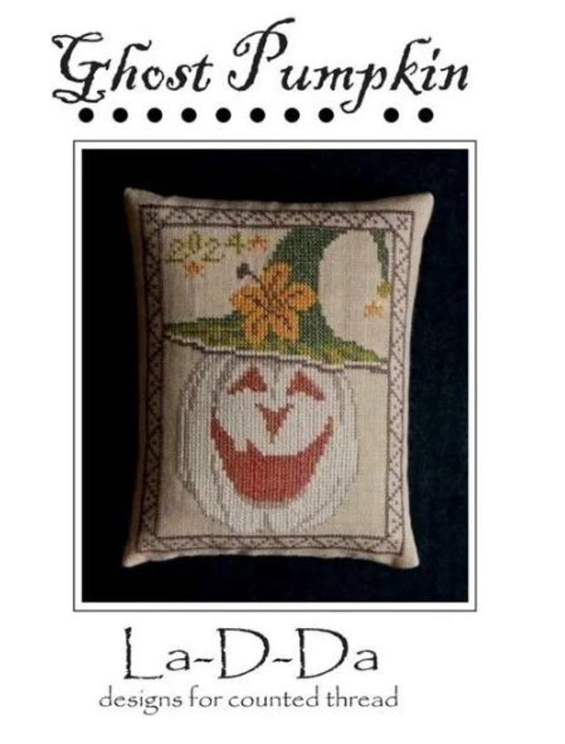 May include: A cross-stitch design featuring a smiling ghost pumpkin wearing a green witch hat with a yellow flower. The design is framed with a decorative border and includes the text "Ghost Pumpkin" and "La-D-Da designs for counted thread".