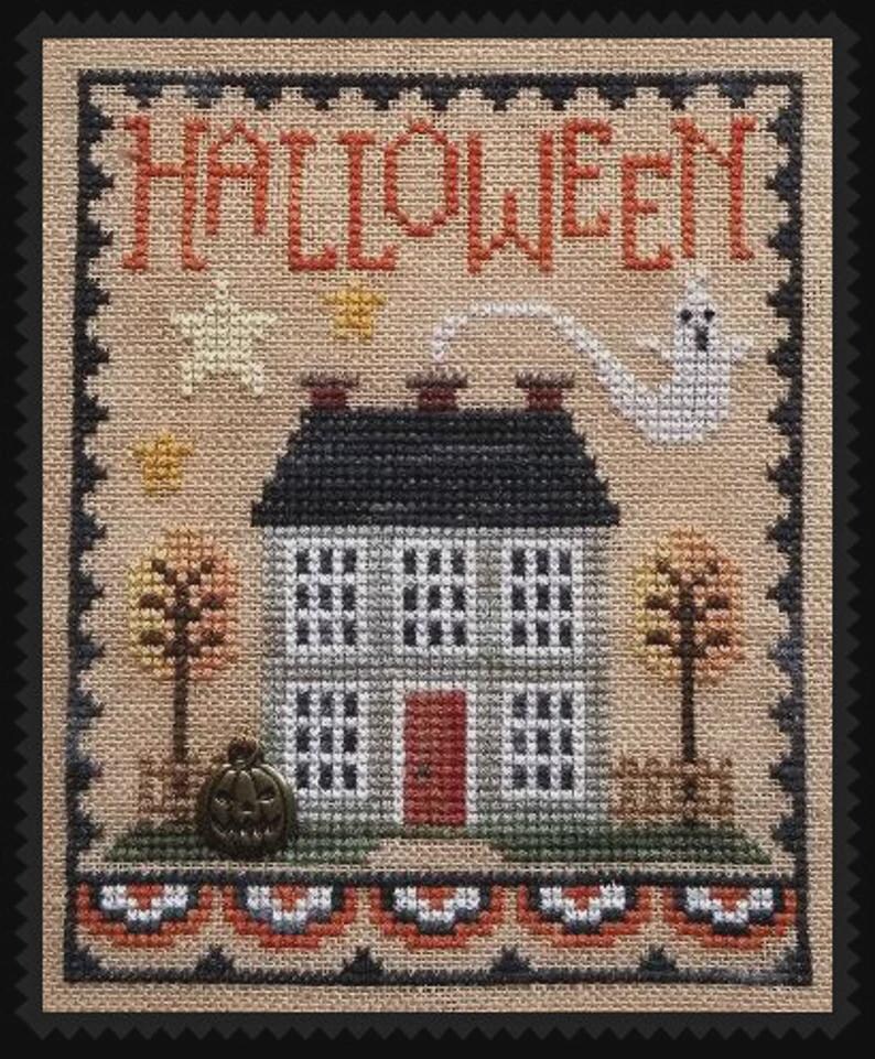 May include: Cross-stitch design featuring a house with a black roof, gray walls, and a red door. The word "HALLOWEEN" is stitched across the top. A ghost, pumpkin, and fall trees complete the festive scene.