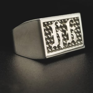 May include: A silver signet ring with a textured rectangular top featuring the letters "FFB" in a stylized font.