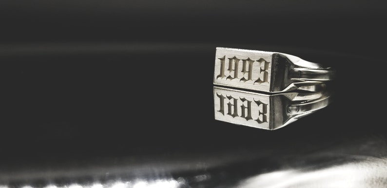 Peut inclure: Une bague en argent avec l'ann&eacute;e 1993 grav&eacute;e en police gothique.