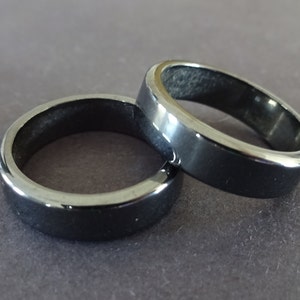 May include: Two black rings made of polished hematite.