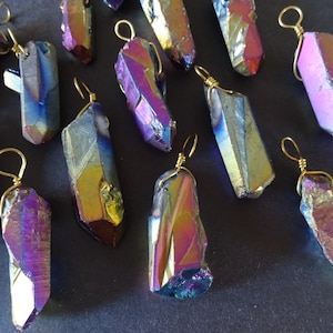 May include: A collection of iridescent, rainbow-colored crystal pendants with gold wire loops. The crystals are raw and have a natural, irregular shape.