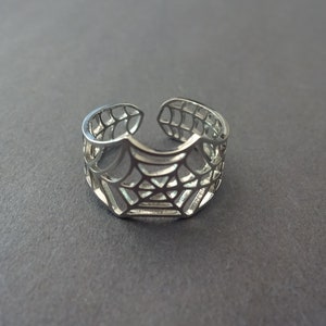 Op de afbeelding: Een verstelbare zilveren ring met een spinnenwebontwerp.