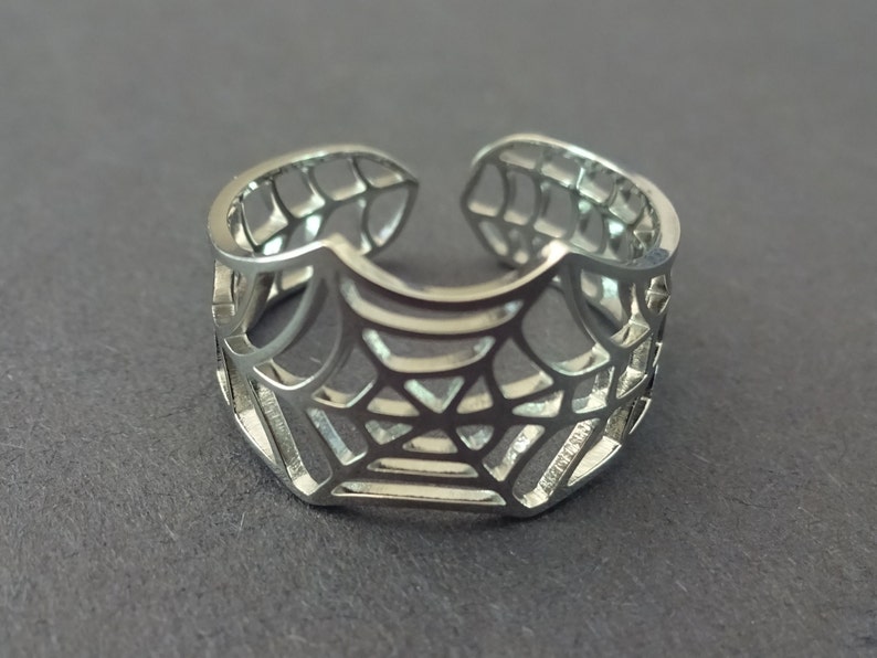 Op de afbeelding: Een verstelbare zilveren ring met een spinnenwebontwerp.