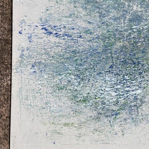 Pode incluir: Pintura abstrata com superf&iacute;cie texturizada. A obra apresenta uma mistura de cores, incluindo branco, azul e verde, criando um efeito em camadas. A pintura &eacute; emoldurada com uma borda preta.