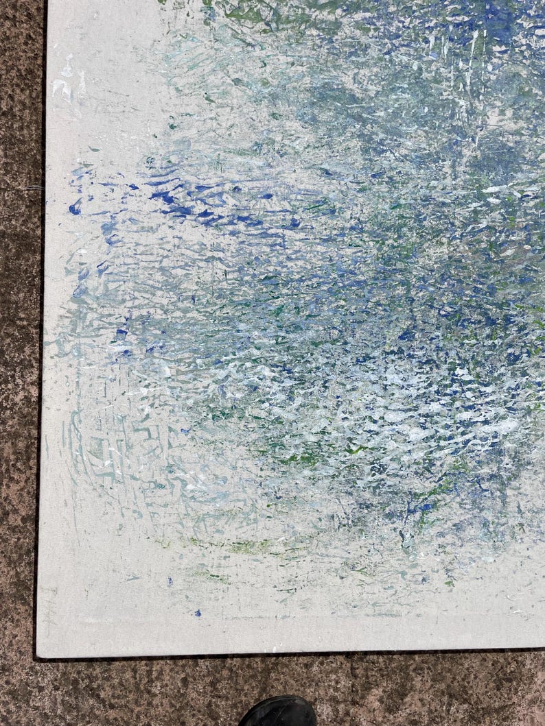 Pode incluir: Pintura abstrata com superf&iacute;cie texturizada. A obra apresenta uma mistura de cores, incluindo branco, azul e verde, criando um efeito em camadas. A pintura &eacute; emoldurada com uma borda preta.
