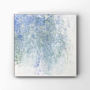 Pode incluir: Pintura quadrada abstrata com uma superf&iacute;cie texturizada. A obra de arte apresenta uma mistura de tons azuis, verdes e brancos, criando um efeito em camadas. A pintura &eacute; emoldurada em uma moldura de metal prateado.