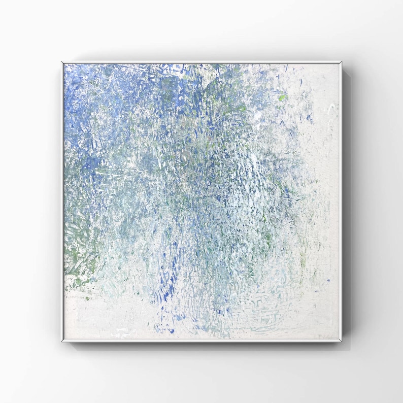 Pode incluir: Pintura quadrada abstrata com uma superf&iacute;cie texturizada. A obra de arte apresenta uma mistura de tons azuis, verdes e brancos, criando um efeito em camadas. A pintura &eacute; emoldurada em uma moldura de metal prateado.