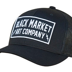 May include: Black trucker hat with a black mesh back and a white logo that says "Black Market Art Company" with lightning bolts on either side.