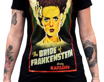 May include: Black t-shirt featuring a graphic of the Bride of Frankenstein from the classic horror film. The design includes the film's title and the actor Karloff's name in a vintage style. The image is framed in red and yellow.