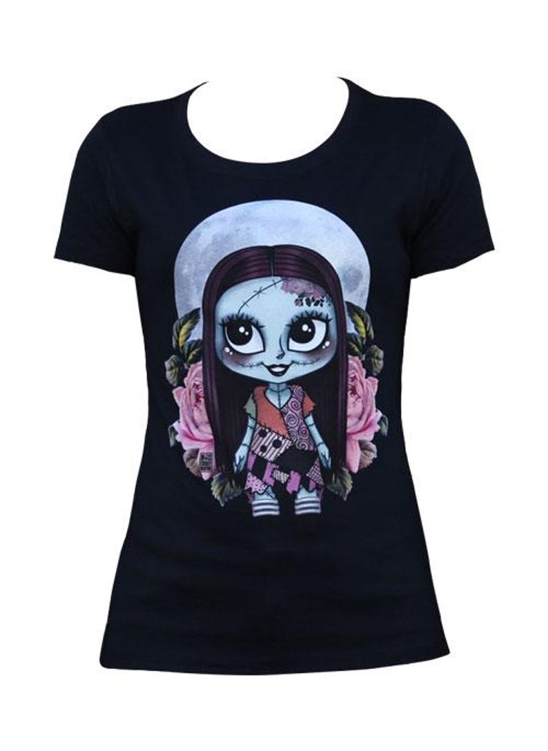 Pode incluir: Camiseta preta com uma ilustra&ccedil;&atilde;o de desenho animado de uma boneca. A boneca tem pele azul, cabelo longo e escuro e um vestido de retalhos. O design inclui uma lua cheia e rosas cor-de-rosa, criando uma est&eacute;tica caprichosa e g&oacute;tica. Uma camiseta gr&aacute;fica &uacute;nica.
