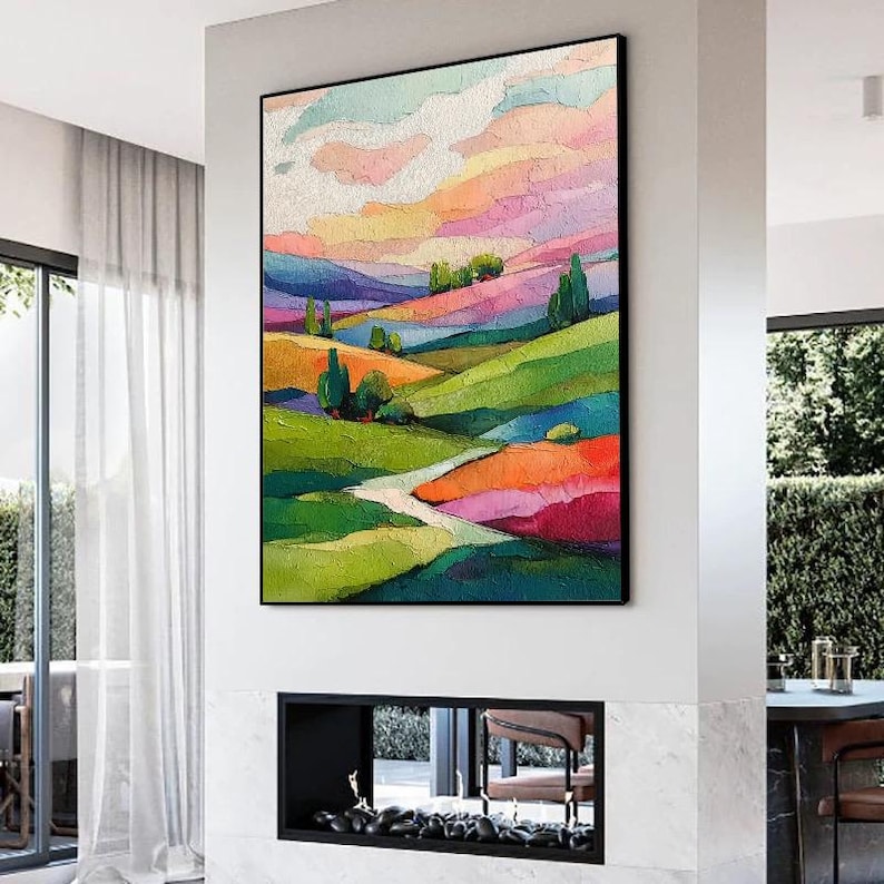 May include: A framed abstract landscape painting with vibrant colors. The artwork features rolling hills in shades of green, orange, and purple, under a sky of pink, yellow, and blue. A winding path leads through the landscape.