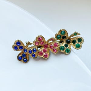 Vintage gold toned metal brooch with glass rhinestones three leaf clover shape,