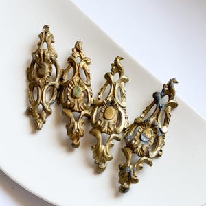 Set di 4 ornamenti angolari per mobili in ottone anticato, applicazioni rococò