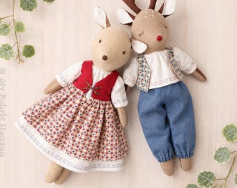 May include: Two plush deer dolls with embroidered facial features. One wears a red vest and a red and white plaid skirt with heart patterns. The other wears a blue plaid vest and blue trousers. Text reads My Fabric Heaven Deer PDF Pattern Bundle.