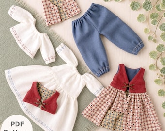 Op de afbeelding: Een collectie poppenkleding bestaande uit een wit shirt met lange mouwen en hartjesborduursel, een blauwe broek met elastische boorden, een rood vest met houtje-touwtjesluiting, een geruit vest, een witte jurk en een geruite rok.