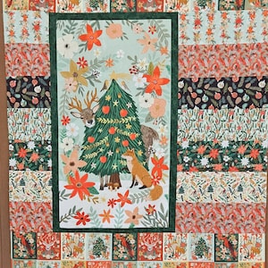 May include: A rectangular quilt featuring a central panel with a green Christmas tree, a deer, and a fox surrounded by orange and white flowers. The border consists of smaller squares displaying cardinals, deer, and trees in red, green, and white.