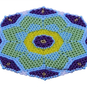 Könnte beinhalten: Ein bunter Perlenuntersetzer mit geometrischem Design in Grün-, Blau-, Gelb- und Violetttönen. Der Untersetzer hat ein zentrales blumenartiges Muster mit gelbem Zentrum und violetten Blütenblättern.