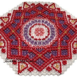 Pode incluir: Um mandala de contas vermelhas, roxas e douradas sobre um fundo branco. O mandala é feito de pequenas contas que são costuradas juntas para criar um design intrincado.