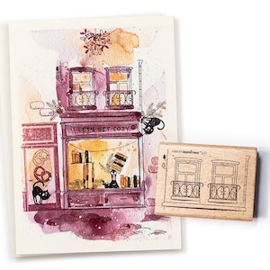 Könnte beinhalten: Eine Aquarellillustration eines gemütlichen Ladens mit dem Text "LET'S GET COZY" und einer schwarzen Katze. Ein Holzstempel mit einem Fensterdesign befindet sich neben der Illustration. Die Farbpalette umfasst Schattierungen von Lila, Braun und Orange.
