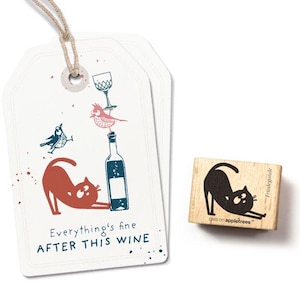 Op de afbeelding: Een wit cadeau-etiket met een rode kat, een wijnfles, een vogel en een glas. De tekst op het etiket luidt "Alles is goed NA DEZE WIJN".