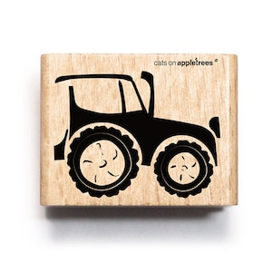 Könnte beinhalten: Ein Holz-Stempel mit einer schwarzen Silhouette eines Traktors. Der Stempel ist mit "cats on appletrees" beschriftet.