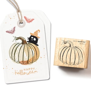 Op de afbeelding: Een houten stempel met een zwart-witte illustratie van een pompoen. De stempel is gelabeld met "cats on appletrees" en "Kürbis 5". De stempel is een knutselbenodigdheid voor het maken van Halloween-kaarten en -knutselwerk.